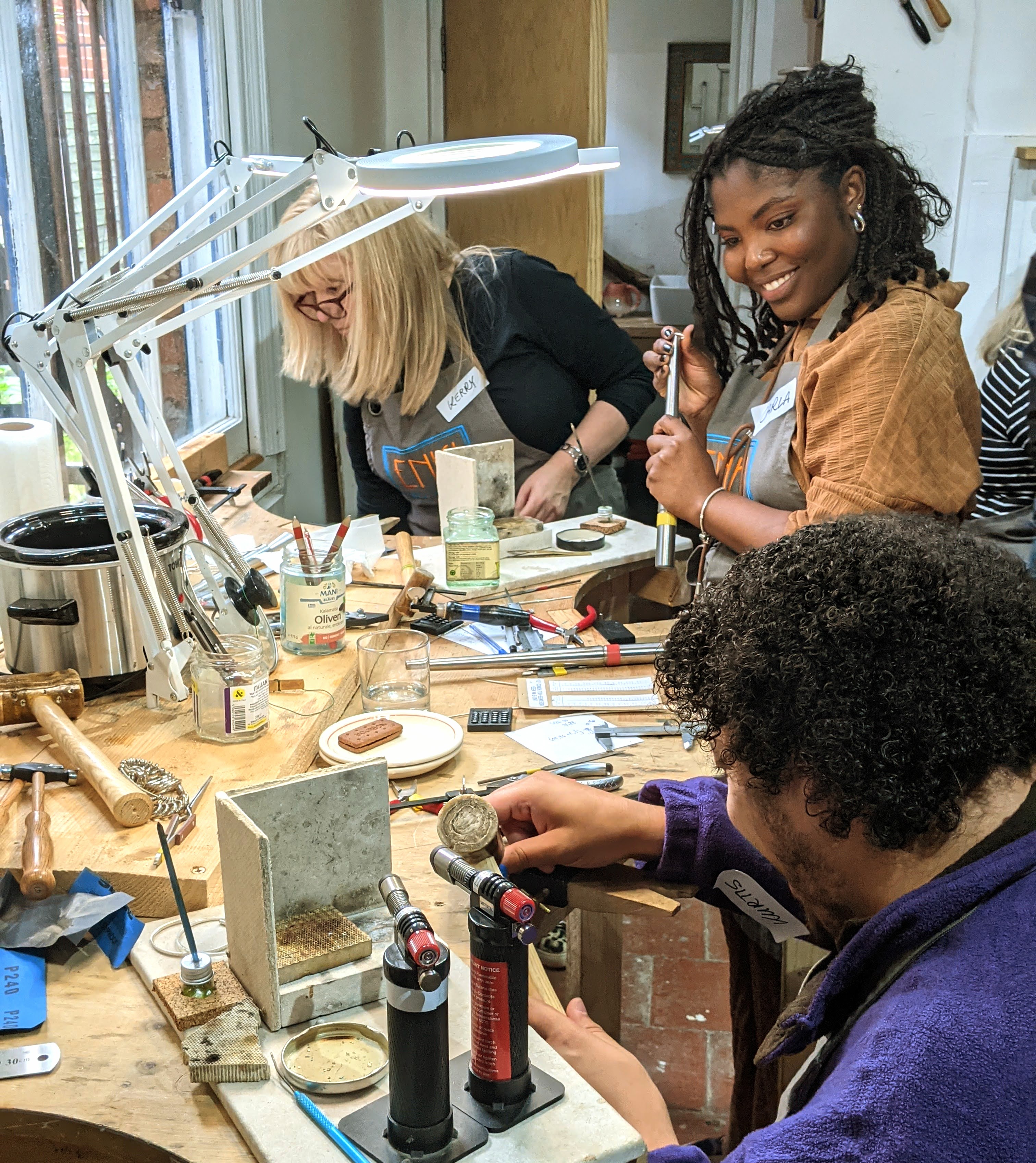 a couple midway through creating their wedding bands