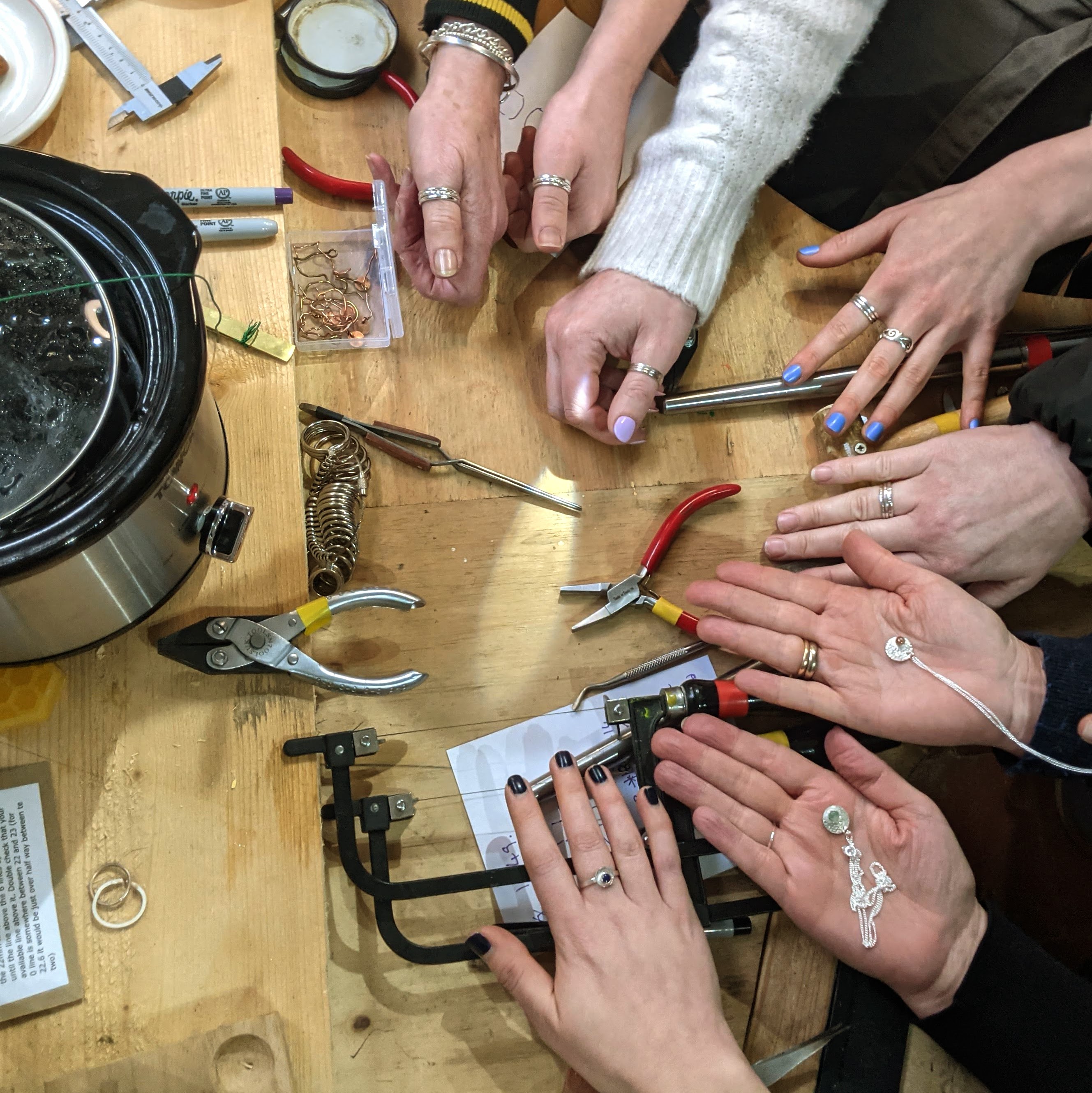 a lady with a blow torch, heating her ring while her partner watches