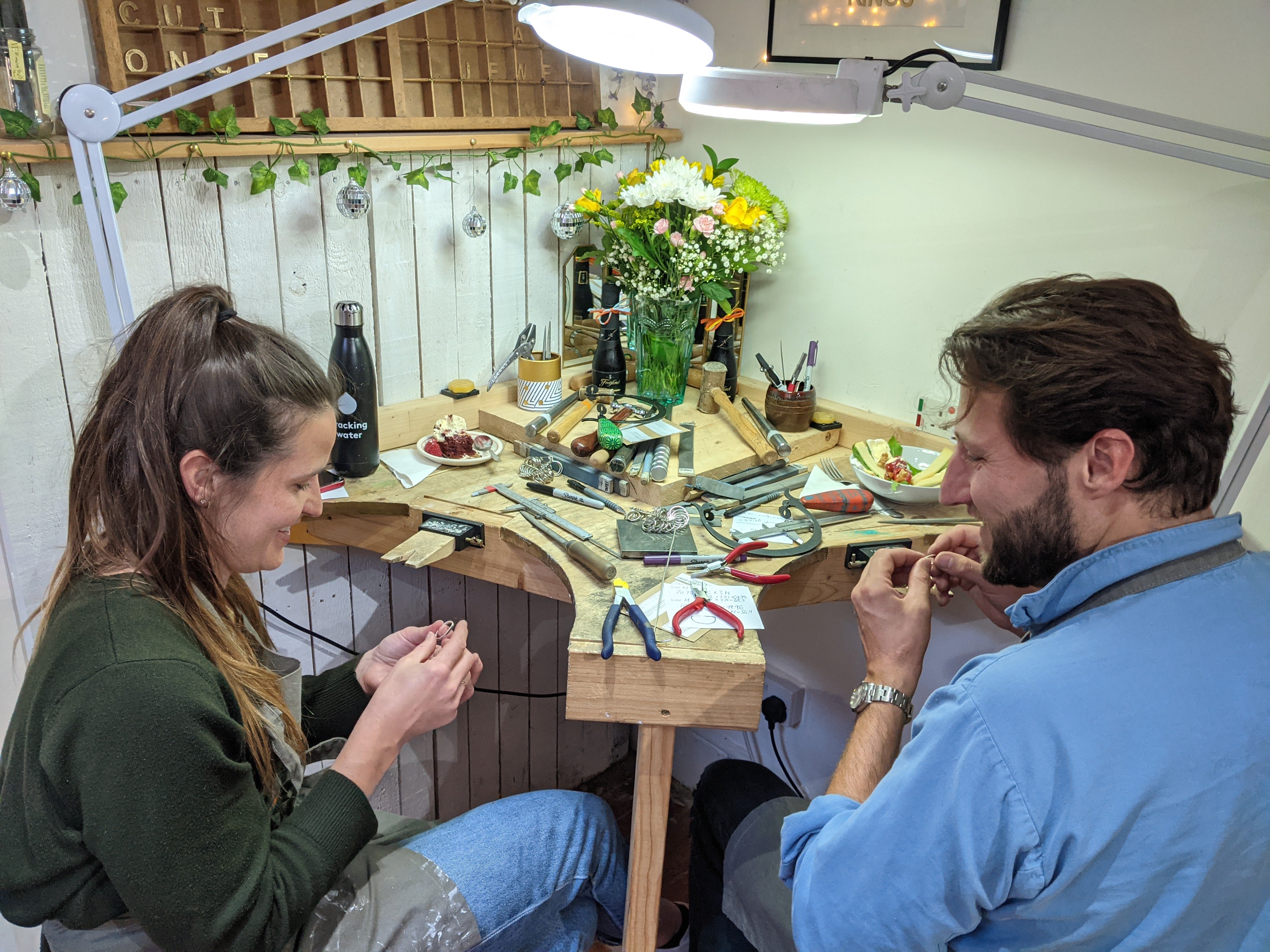 a couple midway through creating their wedding bands